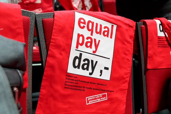 Fotografie - Rote Stofftaschen mit dem Aufdruck Equal Pay Day