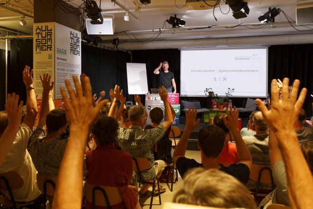 Publikum beim demokratischen Experiment des Vortrags zur Gemeinwohlökonomie