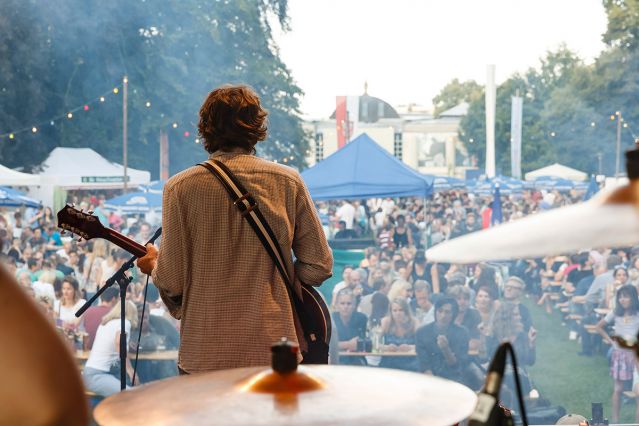 Themenbild Kultur Veranstaltungen - Fotografie - Gitarrist auf einer Bühne - im Hintergrund das Publikum