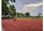 Es sind mehrere Personen auf dem Sportplatz zu sehen.