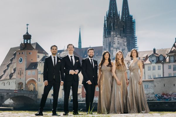 Fotografie –Ensemble in Abendkleidung, Hintergrund Steinerne Brücke und Dom