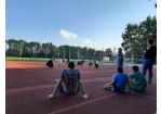 Es sind mehrere Personen auf einem Sportplatz zu sehen.