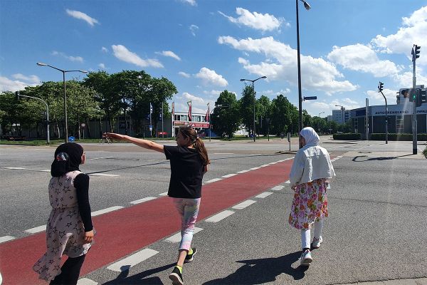 Fotografie - Kinder queren zeigen beim Streifzug, dass sie auf dem Schulweg eine vielspurige Straße überqueren müssen