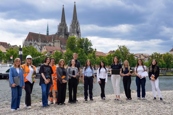 Fotografie - verschiedene Nachwuchskräfte mit Donau und Dom im Hintergrund