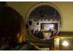 Rundes Fenster in einen Saal mit Bühne