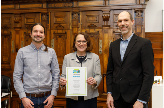 Fotografie: Michael Grein, Oberbürgermeisterin Gertrud Maltz-Schwarzfischer und Dr. Patrick Veit, Personal- und Verwaltungsreferent, mit der Urkunde zur Fairtrade-Stadt