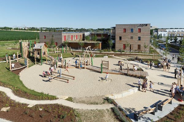 Spielplatz im Neubaugebiet mit inklusiven Steg, der Spielgeräte barrierefrei erreichbar macht